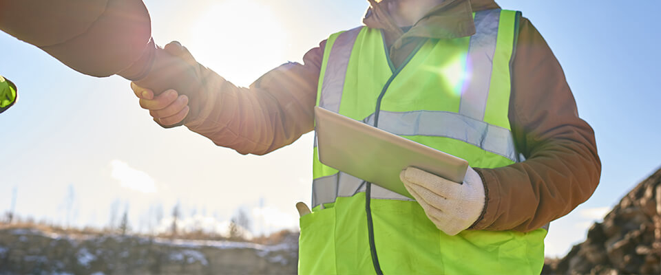 Man wearing hi-vis jacket shaking hands