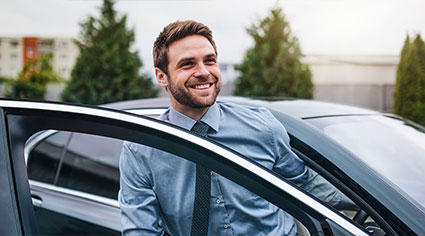 Happy man getting into his car