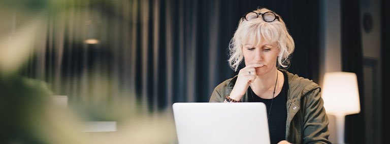 Worried woman sitting at her laptop